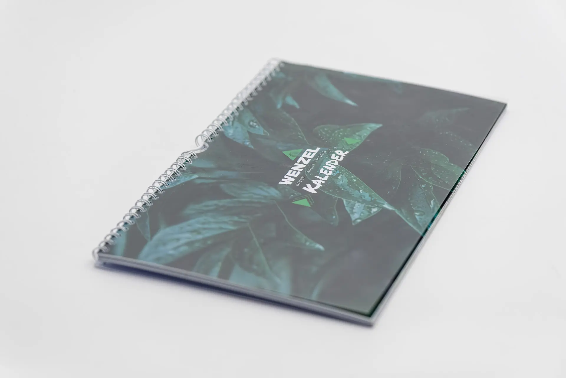 Spiralgebundener Fotokalender mit Blattmotiv und Wenzel-Logo auf dem Titel