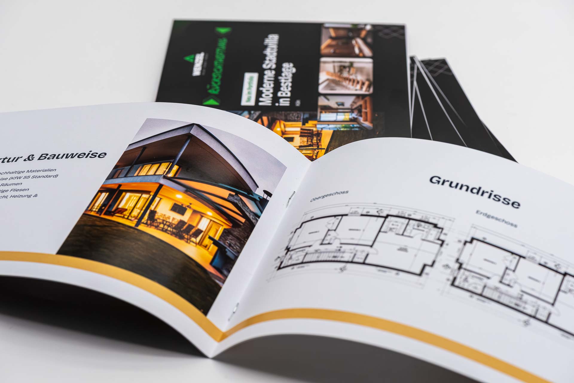 Several sample brochures, landscape format, wire-stitched; one copy is open