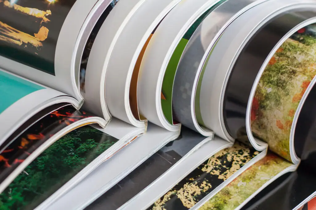 Nahaufnahme von hochwertigen, glänzenden Broschüren mit verschiedenen Bindungen – ideal für Imagebroschüren, Kataloge und Geschäftsberichte